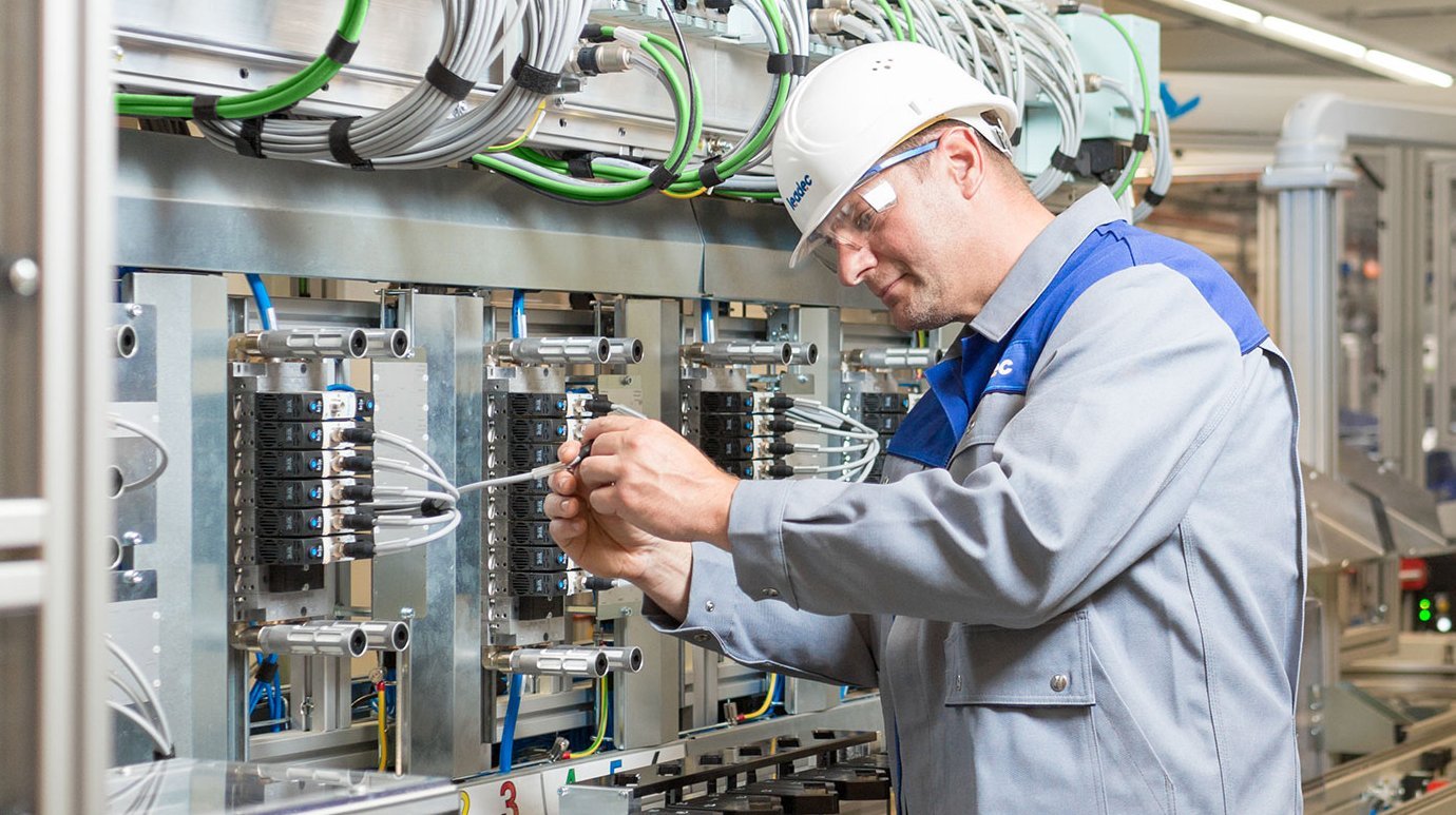 Worker inspecting an electrical Installation at a Leadec plant.
