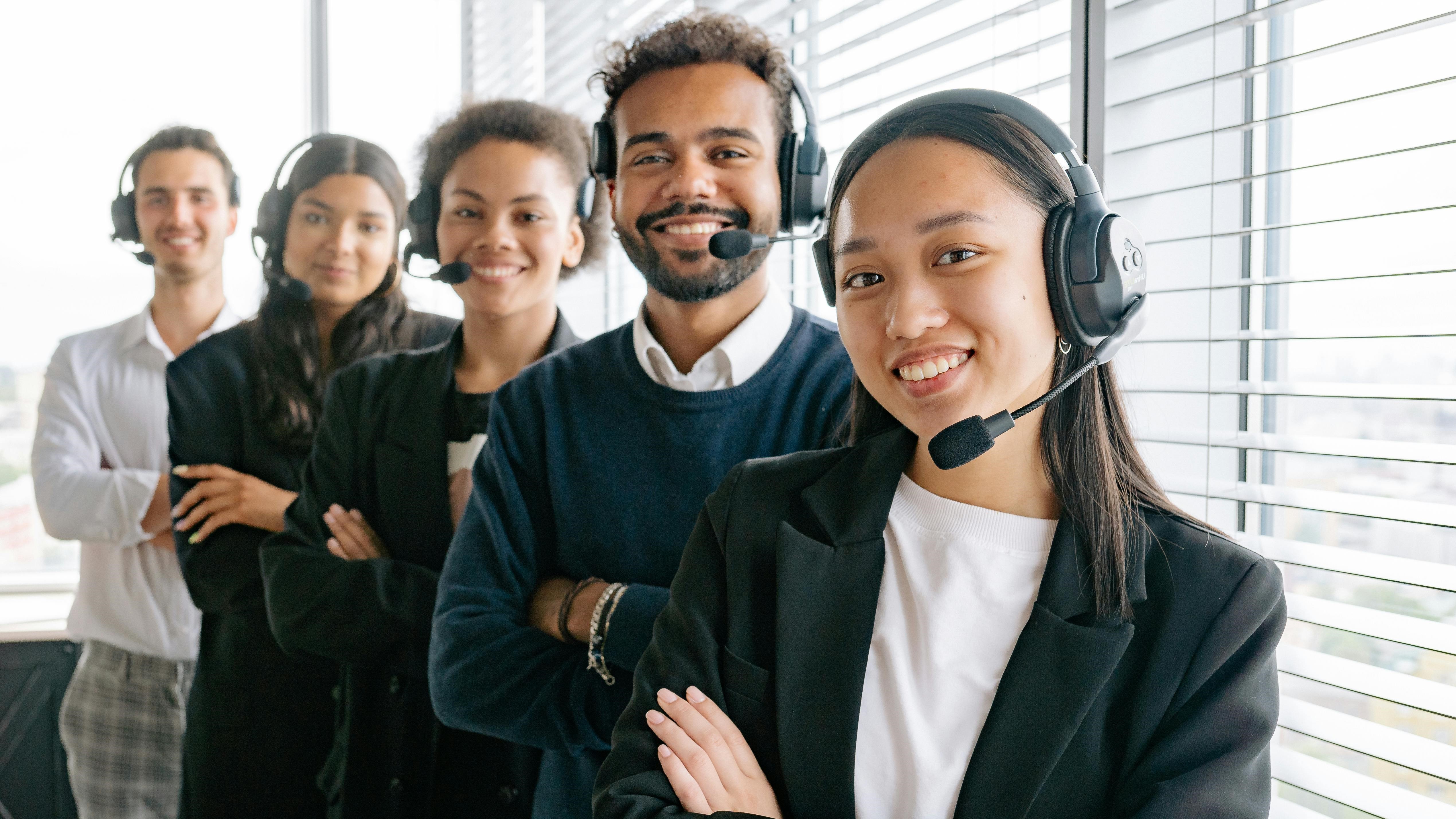 [Translate to Deutschland:] A photo of the male and female customer support phone operator with different internationality